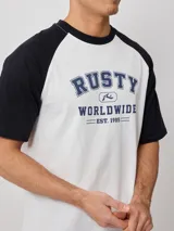Remera blanca con mangas raglán negras y estampado frontal con el logo de Rusty en azul.