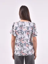 Blusa estampada con cuello en V y lazo ajustable en el escote. Presenta mangas cortas con ligero volumen y un corte holgado con frunces bajo el busto.