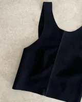 Chaleco negro de cuero agamuzado con espalda cruzada.