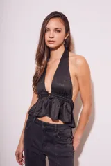 Top negro con escote halter, espalda descubierta y volados en el ruedo.