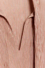 Camisa de algodón con estampado de rayas verticales, cuello subido con lazada frontal, manga larga abullonada y puños ajustados.