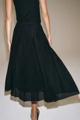 Falda midi de tiro medio de la colección ZARA Woman, confeccionada en mezcla de lyocell con acabado fluido y bajo en línea evasé. Cuenta con forro interior a tono y cierre lateral con cremallera oculta.