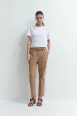 Pantalón de vestir color bordó, de corte recto, con bolsillos laterales y traseros. Se ajusta a la cintura con cinturón de cuero marrón.
