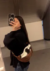 Riñonera bandolera de cuero marrón con bolsillo interno y panel frontal de cuero con estampado animal print de vaca.