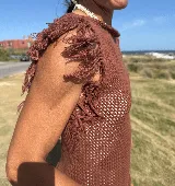 Musculosa tejida color violeta con diseño calado y flecos en los hombros.