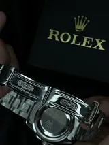 Reloj Rolex Submariner "Batman" con bisel giratorio unidireccional negro y azul, esfera negra con índices luminiscentes, lupa sobre la ventana de fecha y malla de acero inoxidable.