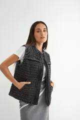Chaleco de denim acolchado con efecto lavado, diseño sin mangas, cierre frontal y bolsillos laterales.