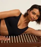 Top deportivo negro, confeccionado en tejido seamless de poliamida y elastano, con escote en U y breteles ajustables. Presenta una banda inferior texturizada y copas removibles.