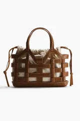 Bolso tote marrón estructurado con armazón exterior de cuero sintético entrelazado e interior de lona de lino y algodón con cordones ajustables.