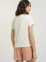 Pijama compuesto por una remera de algodón color crema con estampa pequeña en el pecho y un short de tela liviana color beige con estampado de cuadrícula fina.