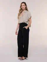 Blusa crop cruzada Allie Rose de tela liviana negra con estampado de lunares blancos, escote en V y cuello camisero.