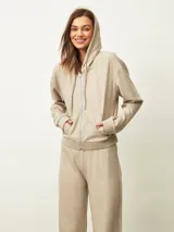 Campera negra con capucha, cierre frontal, mangas largas con puños elásticos y bolsillos laterales.