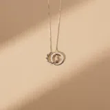 Collar de plata 925 con cadena fina y dije compuesto por dos aros entrelazados, uno de superficie lisa y otro con diseño trenzado.