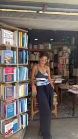 Collar de mostacillas de acrílico color turquesa con un dije colgante en forma de cuerno italiano (cornicello) rojo con incrustaciones de piedras turquesas. El engarce del dije y las cuentas separadoras son de metal dorado.