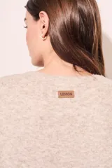 Sweater color visón de punto texturado, corte holgado y cuello redondo.