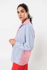 Camisa a rayas rojas y blancas en un lado y azules y blancas en el otro, con corte en A y abertura central con botonadura doble.