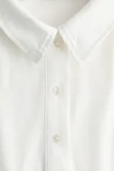 Remera polo de manga larga confeccionada en punto de algodón, con cuello clásico, tapeta frontal con botones y costuras moldeadoras en el frente.