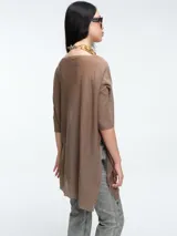 Sweater tipo túnica de tejido liviano con sutil transparencia y acabado brillante. Presenta escote en V, mangas largas relajadas y un corte amplio con largo asimétrico.