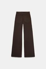 Jeans de tiro alto con corte wide leg y largo completo. Presenta diseño de cinco bolsillos, trabillas en la cintura y cierre frontal con cremallera y botón, con un acabado de efecto lavado.