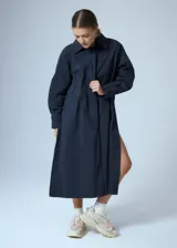 Trench midi color negro, confeccionado en mezcla de algodón y nylon con acabado repelente al agua. Presenta diseño con tajos laterales, bolsillos internos y etiqueta de marca en la espalda.