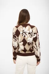 Buzo de tejido de punto con diseño de rombos y flores estampadas en tonos marrón y beige, de cuello redondo y manga larga.