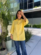 Camisa de manga corta color amarillo, con cuello clásico y botones frontales.