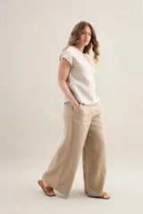 Blusa de silueta amplia y relajada, confeccionada en lino con cuello redondo, mangas cortas y recorte diagonal en el frente.