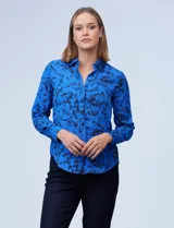 Camisa de gasa estampada con flores negras sobre fondo azul. Cuello con solapa y abertura central con botones.