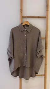 Camisa verde militar de lino italiana con botones de nácar, corte holgado, cuello camisero y mangas cortas con dobladillo.