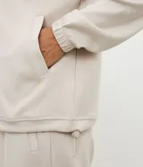 Campera deportiva de cuello alto con cierre frontal, mangas largas con puños elásticos y diseño de corte raglán. Presenta un estilo minimalista y funcional con cintura ajustable.