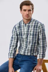 Camisa de manga larga de calce slim, con diseño a cuadros en tonos azul oscuro, verde y blanco. Presenta cuello camisero con botones y bolsillo ojal en el pecho con detalle bordado.