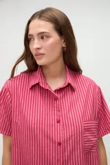 Camisa de manga corta de algodón con diseño a rayas en tonos amarillo y blanco, calce holgado, cuello solapa y bolsillo aplicado en el pecho.