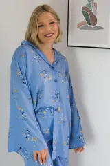 Camisa celeste con estampado floral en tonos amarillos y azules, de corte holgado y mangas anchas.