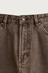 Pantalón barrel fit de mezclilla color verde militar, con efecto lavado, cinco bolsillos, cierre frontal con cremallera y botón, y detalle de pinzas en las rodillas.
