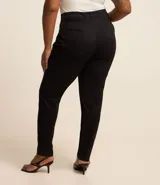 Pantalón skinny de sarga color negro, con cintura con trabillas, elástico regulador interno, cierre por cremallera y botón, y bolsillos.