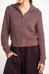 Cardigan tejido de algodón en color marrón, con cuello solapa, cierre frontal completo con cremallera y diseño de canalé ancho.