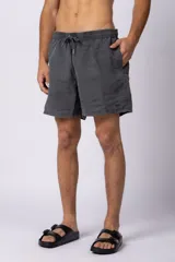 Short de baño de corte clásico con cintura elástica y cordón ajustable. Presenta un acabado efecto lavado vintage, bolsillos laterales y un pequeño logo bordado en la parte inferior.