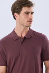 Remera polo de manga corta en color azul melange, con cuello camisero, cierre frontal de dos botones y pequeño bordado en el pecho.