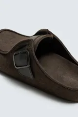Zueco destalonado de fieltro color marrón, con detalle de hebilla metálica ajustable y costura en el empeine.