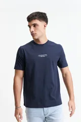 Remera de manga corta color azul marino con cuello redondo y calce regular. Presenta un estampado gráfico en la espalda que incluye un paisaje montañoso al atardecer, el texto 'KINDNESS MATTERS' y el logo de la marca Mistral.