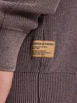 Sweater de punto en color azul marino, con cuello redondo y mangas raglán. Presenta un tejido acanalado fino y puños elásticos.