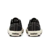 Zapatillas John Foos modelo 182 Rue, de caña baja, color negro con detalles en blanco. Capellada de lona poliéster, forrería de algodón, ojalillera de aluminio color bronce y cordones chatos encerados. Banda de caucho color crudo con serigrafía de geolocalización y filete inferior ancho color negro.