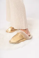 Pantuflas doradas de cuero ovino con interior de lana natural.