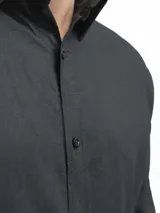 Camisa de manga larga, color blanco, con cuello camisero y botones frontales. El tejido presenta una textura visible de lino.