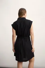 Vestido camisero corto negro con cuello clásico, solapas, cierre frontal con botones, cinturón de lazo y bolsillos laterales.