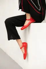 Chatitas rojas de cuero con correa sobre el empeine y hebilla metálica.