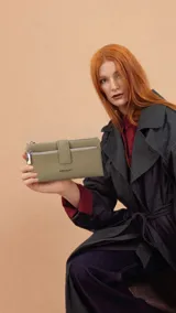 Billetera Lincoln's de mujer en color negro, confeccionada en símil cuero con textura granulada. Presenta un diseño rectangular con cierre de broche, bolsillo frontal con cierre metálico, correa de mano extraíble y logo de la marca grabado en el frente.