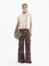 Chaleco de tejido de punto en color celeste, con cuello redondo y mangas cortas con terminación en rib. Presenta un diseño holgado con aberturas laterales en el ruedo y un pequeño bordado decorativo en la parte inferior.