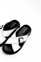 Sandalias de cuero blancas con suela negra, tiras cruzadas y hebillas ajustables.