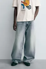 Jeans de denim de algodón, color azul oscuro con efecto lavado. Presentan un corte muy holgado (baggy fit) en toda la pierna y tiro medio. Tienen cinco bolsillos y cierre frontal con cremallera y botón.